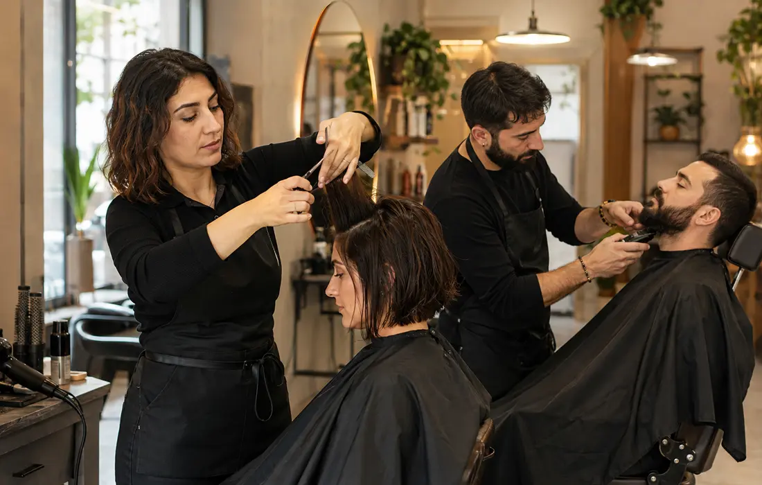 Modern kuaför salonunda saç kesimi ve şekillendirme yapan kuaförler