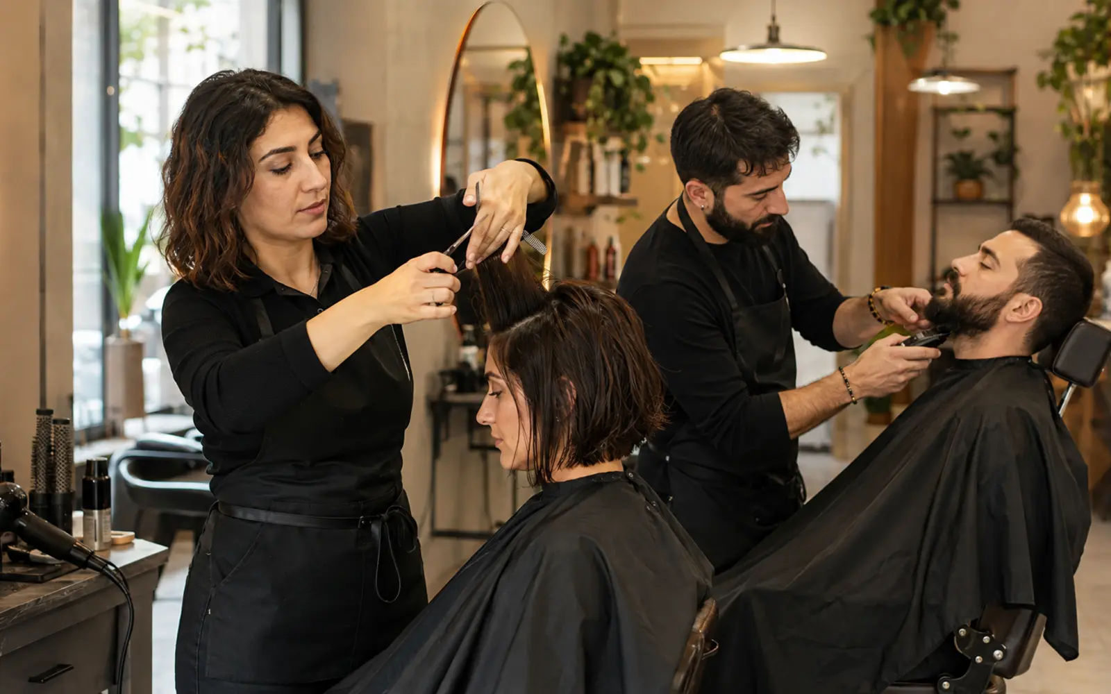 Modern kuaför salonunda saç kesimi ve şekillendirme yapan kuaförler